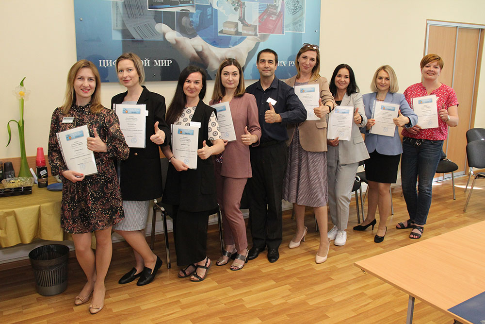 Группа девушек позирует с сертификатами в руках, улыбаясь в офисной обстановке Форинтека